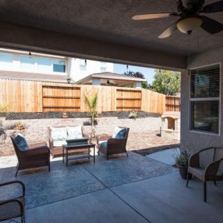 A cozy backyard patio with comfortable seating and a wooden fence.