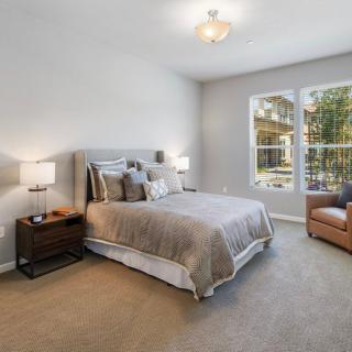 A modern bedroom with neutral tones and cozy furnishings.