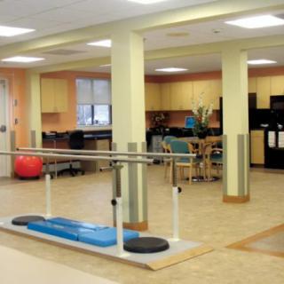 A physical therapy and rehabilitation room equipped with parallel bars and exercise equipment.