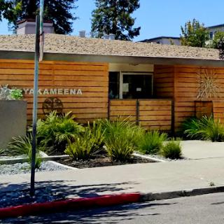 A modern architectural structure with wooden elements and landscaping.