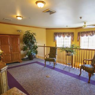 A cozy lobby area featuring comfortable seating, decorative plants, and ample natural light through the windows.