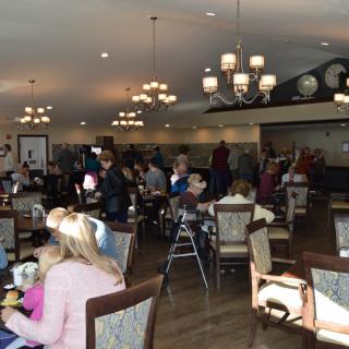 A busy restaurant dining area filled with people enjoying their meals.