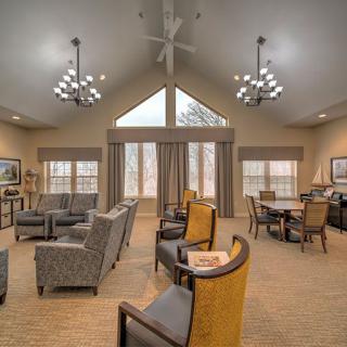 A spacious lounge area with elegant furniture and large windows, featuring contemporary lighting fixtures.