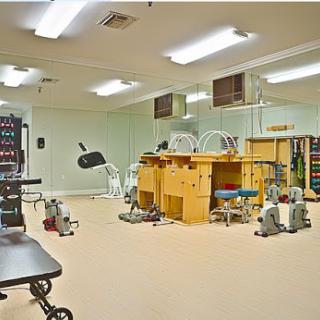 A spacious therapy room equipped with various medical devices for rehabilitation and wellness.