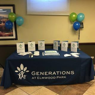 A table display at an event for Generations at Elmwood Park, featuring brochures and balloons.