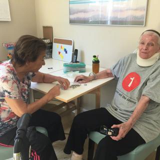 A nurse assists a patient during a rehabilitation session in a care facility.