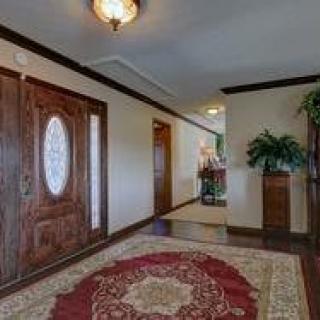 A traditional home hallway featuring a wooden door and a decorative rug.