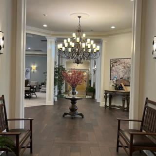 A well-lit lobby area featuring a chandelier, seating, and decorative elements.