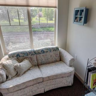 A cozy living room corner with a floral couch by the window.
