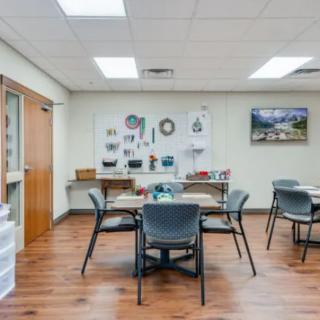 A well-organized craft room with tables and chairs, decorated with various art supplies and decorations on the walls.