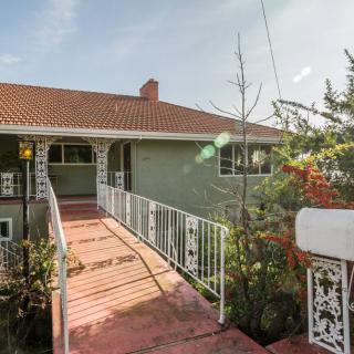 A residential house with a ramp leading to the entrance, surrounded by greenery.