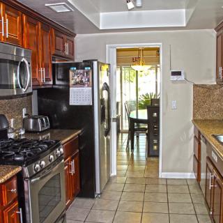 A modern kitchen with stainless steel appliances and wooden cabinets.