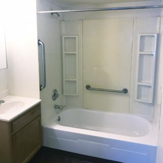 A clean bathroom with a bathtub, shower, and sink.