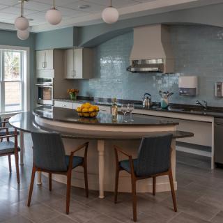 A modern kitchen with a curved countertop and stylish seating.