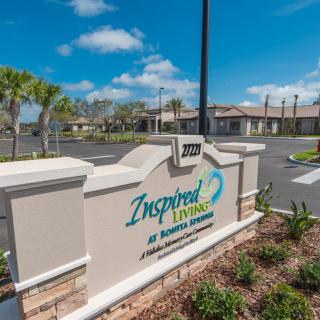 Entrance sign for a residential or community facility with landscaped surroundings.