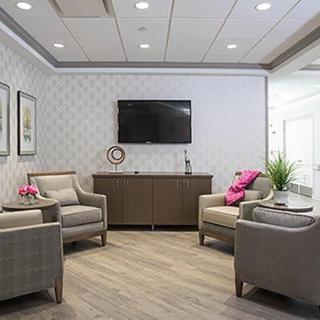 A modern waiting room with comfortable seating and a television.