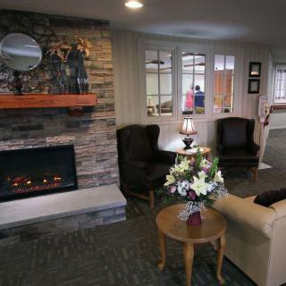 A cozy living room with a stone fireplace and comfortable seating.