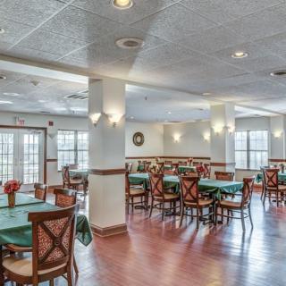 Spacious dining area with neatly arranged tables and chairs, featuring ample natural light.