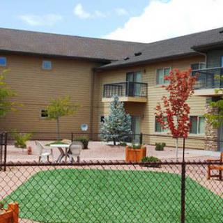 A view of a courtyard in an apartment complex, featuring outdoor seating and landscaped greenery.