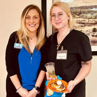 Two healthcare professionals enjoying a social event with snacks.