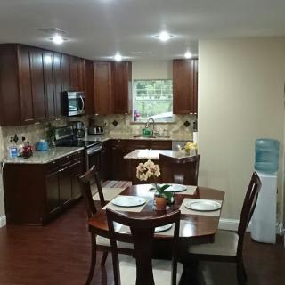 A cozy kitchen and dining area featuring wooden cabinets, a round table set for dinner, and modern appliances.