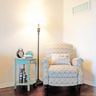 A cozy reading nook with an armchair, side table, and floor lamp.