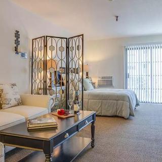 A cozy interior space featuring a bedroom and living area separated by a decorative screen.