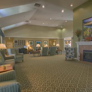A spacious lounge area with comfortable seating and a fireplace, adorned with artwork and soft lighting.