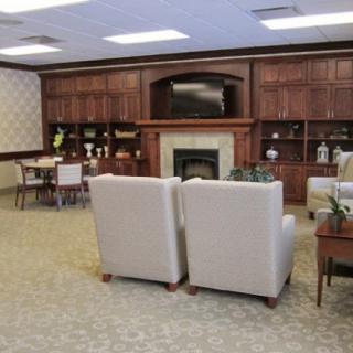 A cozy living room with beige seating, a fireplace, and wooden shelves.