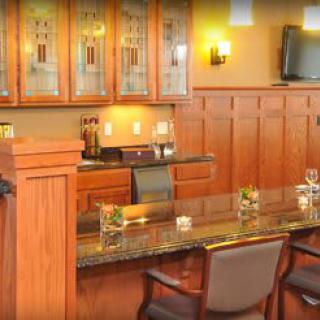 A cozy bar area with wood paneling, a sleek countertop, and comfortable seating.