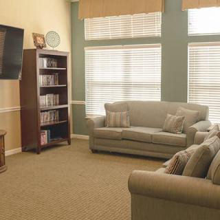 A cozy living room with sofas, a television, and a bookshelf.