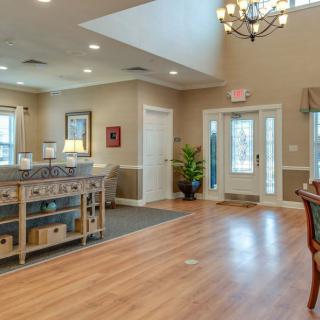 A spacious and elegantly decorated foyer with wood flooring and a chandelier.