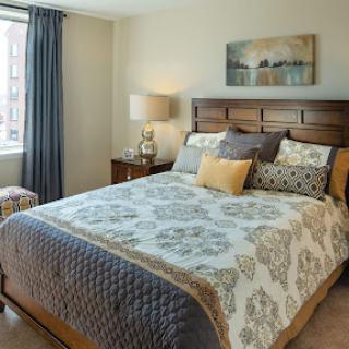 A cozy and elegantly designed bedroom featuring a comfortable bed with decorative pillows, soft lighting, and stylish curtains.
