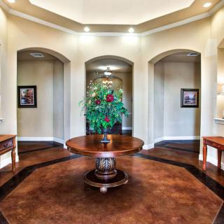 A beautifully decorated foyer with a central table and plant arrangement.