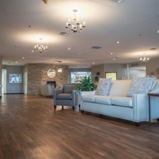 A spacious and elegantly designed living room featuring modern furniture and warm lighting.