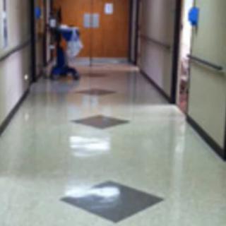 A janitor cleaning a hospital hallway.