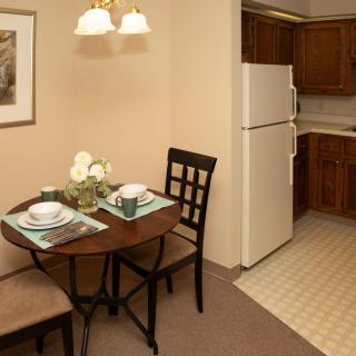 A cozy dining area with a neatly set table adjacent to a kitchen.