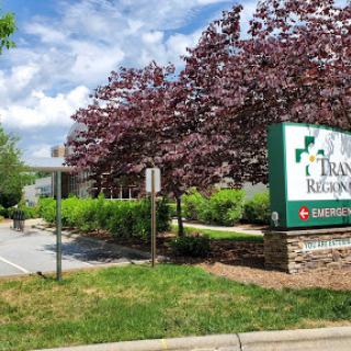 Entrance to a facility surrounded by blooming trees and blue skies.