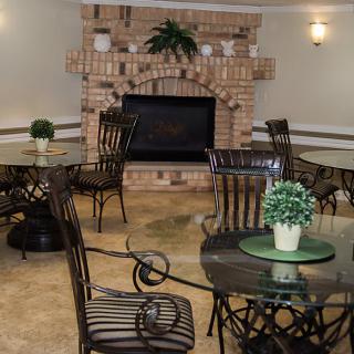 A cozy interior with a brick fireplace and arranged seating.