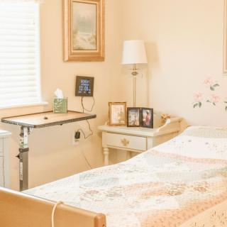 A cozy bedroom with a hospital bed, featuring decorative elements and soft lighting.