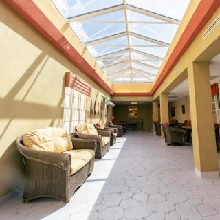 A sunlit hallway with comfortable seating and a skylight.