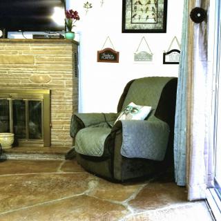 A cozy living room with an armchair next to a fireplace.