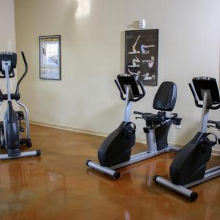 A fitness room with stationary bikes and an elliptical machine.