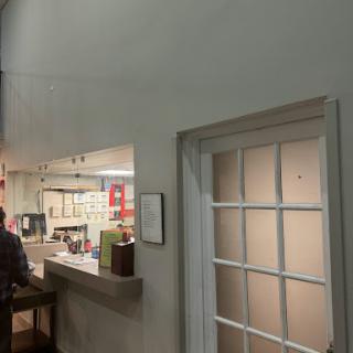 A glimpse of a restaurant interior showcasing the counter and an adjacent door.