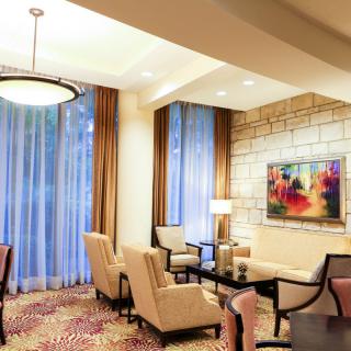 A modern living room with stylish armchairs, a coffee table, and colorful artwork on the wall.