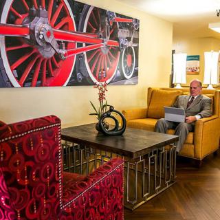 A modern living room with vibrant artwork and comfortable seating.