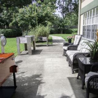 A cozy patio with outdoor seating and lush garden views.