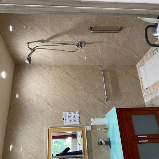 A modern bathroom with a shower area, glass door, and tile walls.