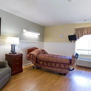A cozy room with a single bed, television, and window view.
