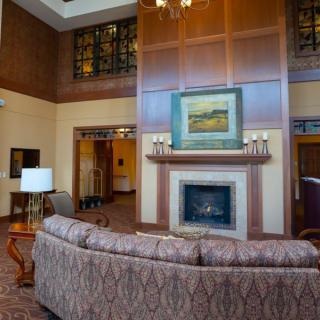 A cozy living room with a fireplace, comfortable sofa, and elegant artwork above the mantel.